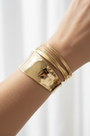 Fair skin – chunky gold cuff & bangles, wrist close-up